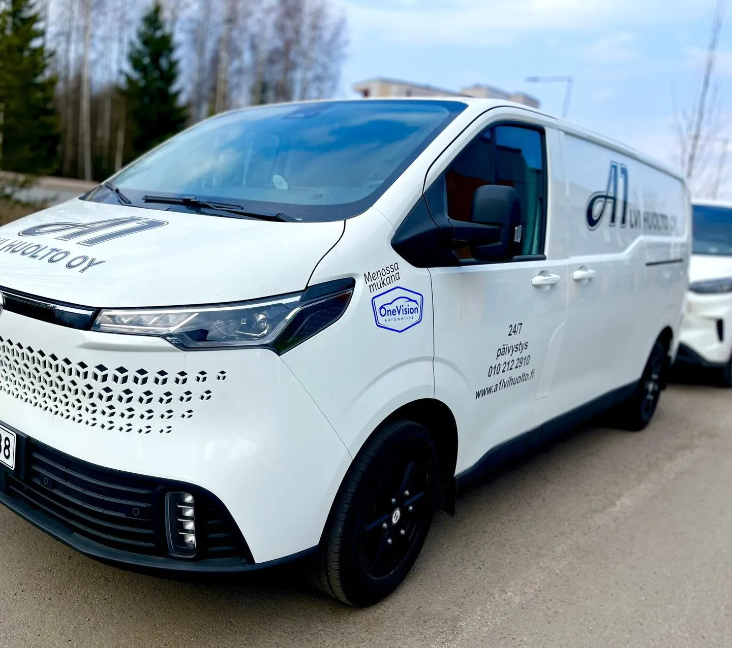 Valkoinen huoltoauto, jossa on mustat vanteet ja LVI-palveluihin liittyviä merkintöjä, on pysäköity ulkona.